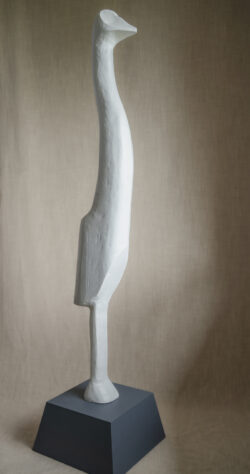 Tall abstract wood carving sculpture of emu-shaped figure painted white with grey wood base
